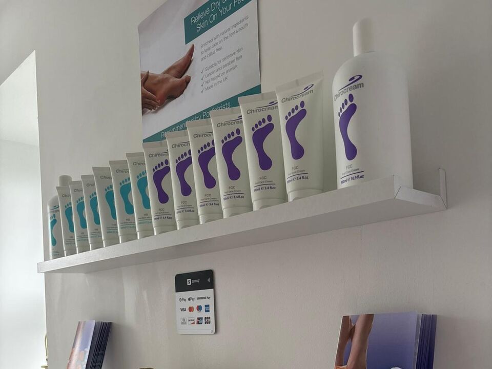 The clinic's Chirocream foot care creams lined up along a white shelf, with an information poster behind them